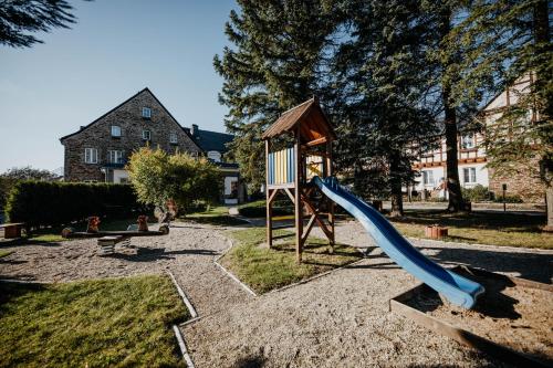 a playground with a blue slide and a play structure at Sonnenhotel Hoher Hahn in Schwarzenberg