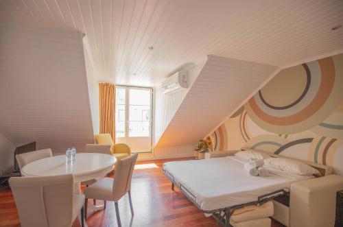 um quarto com uma cama e uma mesa e uma mesa e cadeiras em Grande Pensao Residencial Alcobia em Lisboa