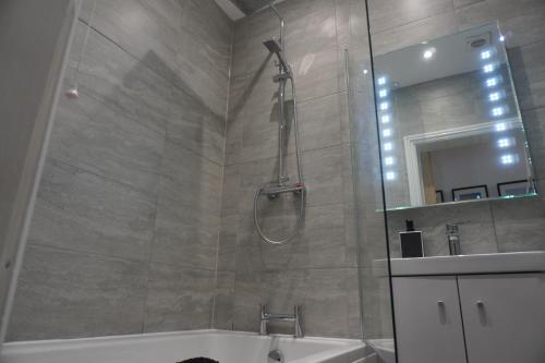 a bathroom with a shower and a tub and a sink at Seaside Apartment close to beach, town, station in Broadstairs