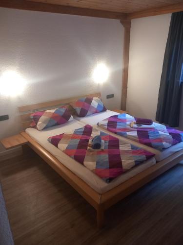 a bed with a plaid blanket and pillows on it at Haus Heidelberg in Feldberg