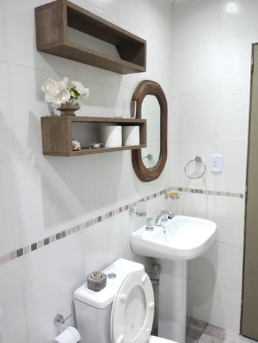 a white bathroom with a toilet and a sink at Hospedaje La Bussola II in Gualeguaychú