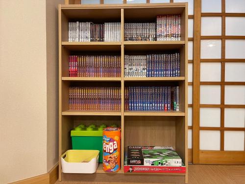 a book shelf filled with lots of dvds at 源泉かけ流しの露天風呂を独り占め！一棟貸切旅館「御宿あさか」29名まで宿泊可 in Ena