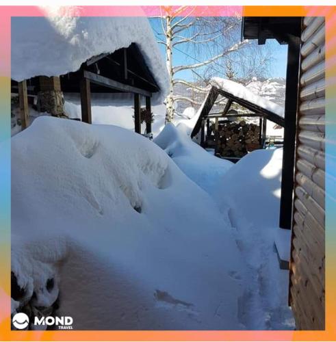 una pila de nieve junto a una casa en Vila Sara, en Mavrovi Anovi