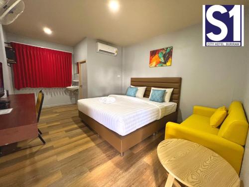 a bedroom with a bed and a yellow couch at S1 City Hotel Buriram in Buriram