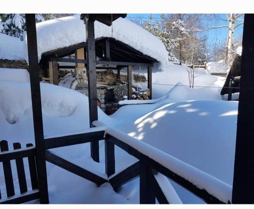 un cenador cubierto de nieve en un patio en Vila Sara en Mavrovi Anovi