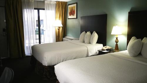 a hotel room with two beds and a window at Wyndham Garden Detroit Metro Airport in Romulus