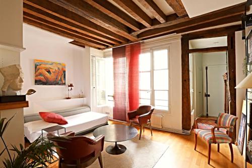 un salon avec un canapé et une table dans l'établissement Chic Flat Paris VI, à Paris