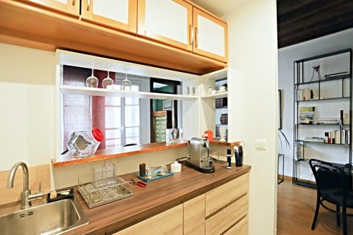 d'une cuisine avec un comptoir, un évier et une fenêtre. dans l'établissement Chic Flat Paris VI, à Paris