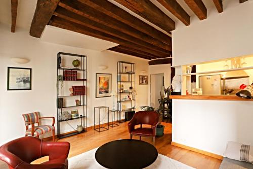 un salon avec une table et des chaises dans l'établissement Chic Flat Paris VI, à Paris