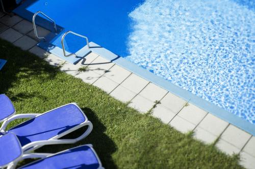 two blue chairs sitting next to a swimming pool at Sonnenberg in Silandro