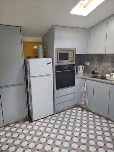 a kitchen with a refrigerator and a microwave at Apartamento Estoril in Estoril