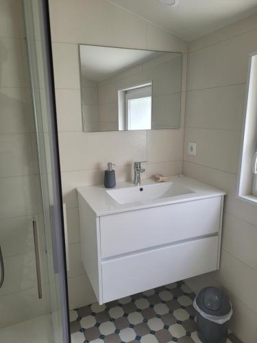 y baño con lavabo y espejo. en Apartamento Estoril, en Estoril
