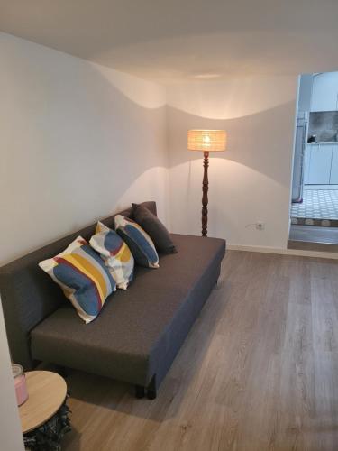 a couch with pillows and a lamp in a room at Apartamento Estoril in Estoril