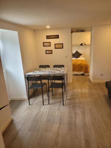 a room with a table and two chairs and a bed at Apartamento Estoril in Estoril