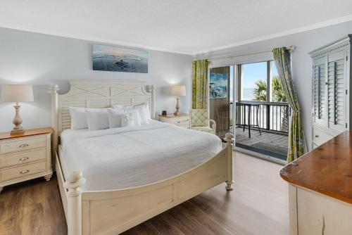 1 dormitorio con 1 cama grande y balcón en Gorgeous Oceanfront 2 Bedroom Villa, en Pawleys Island