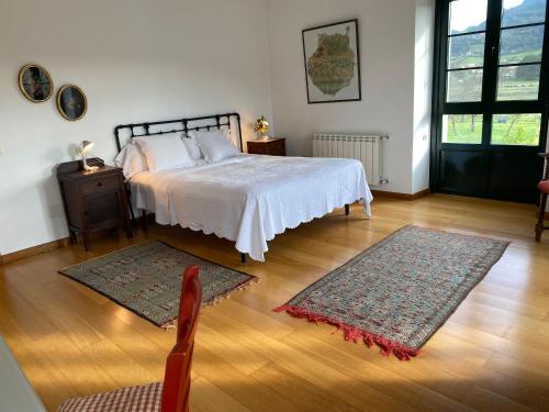een slaapkamer met een bed en twee tapijten op de vloer bij LA QUINTA DE TUNTE in Villaviciosa