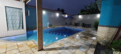 una piscina en un patio trasero por la noche en Pousada Casa Familia en Nova Iguaçu