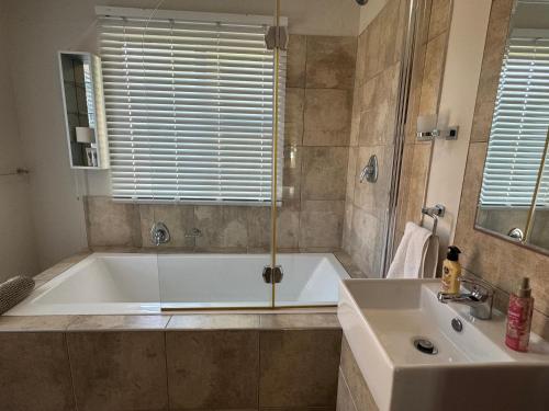 a large bathroom with a tub and a sink at Lieben Gast in De Kelders