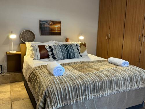 1 dormitorio con 1 cama grande y toallas azules. en Lieben Gast, en De Kelders