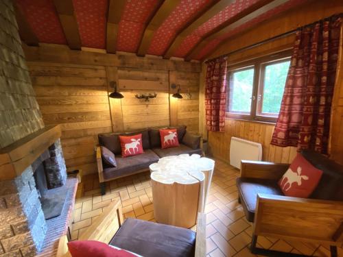 un salon avec un canapé et une cheminée dans l'établissement LE TRAPPEUR Chalet en bois, à La Bresse
