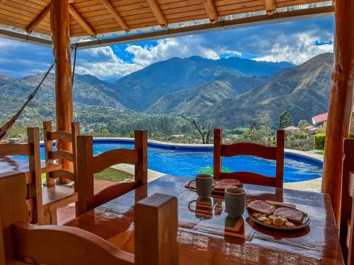 a table with food and a view of mountains at Vistabamba Ecuadorian Mountain Hostel in Vilcabamba