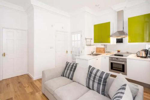 sala de estar blanca con sofá y cocina en Orchard Street: 1BR with Garden en Bath