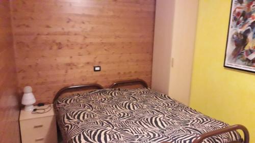 Dormitorio con cama con estampado de cebra en una habitación en Casa Carona, en Carona