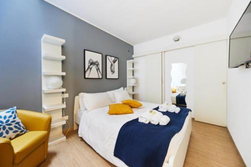 a bedroom with a bed and a yellow chair at iFlat Wonderful Home in Monti in Rome
