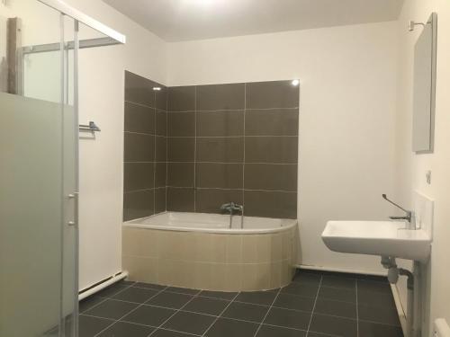 een badkamer met een bad en een wastafel bij Aladin resort in Bouconvillers