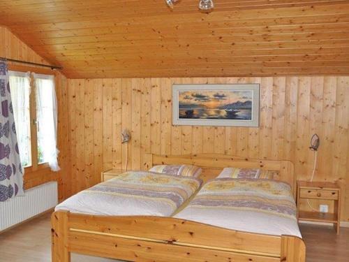 a bedroom with a bed in a wooden cabin at Chalet Huber 6-Bettwohnung in Meiringen