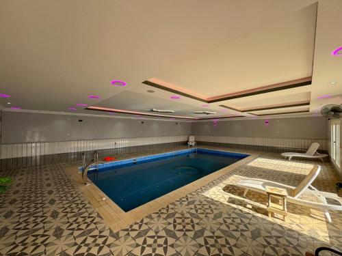 Una gran piscina en una habitación con en شاليه مجهز بالكامل مسبح وملعب و حديقه هادئه بضباء en Ḑubā