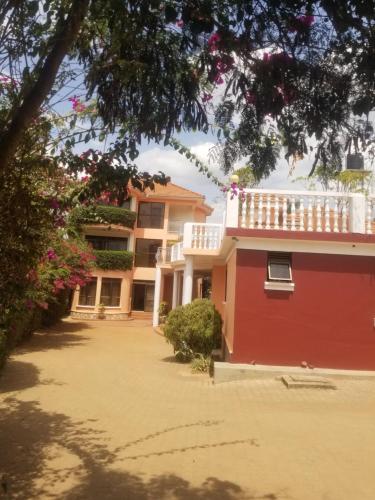 Casa con un edificio rojo con balcón en Spannet Suites, en Mbarara