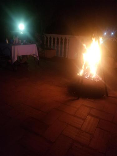 una persona está de pie alrededor de un fuego en la oscuridad en Spannet Suites en Mbarara