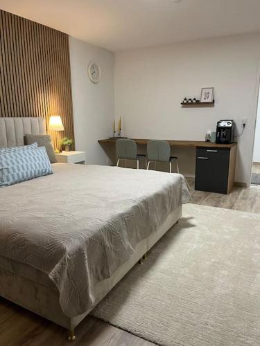 1 dormitorio con 1 cama, mesa y sillas en Isaak Appartement Harmonie, en Küssaberg