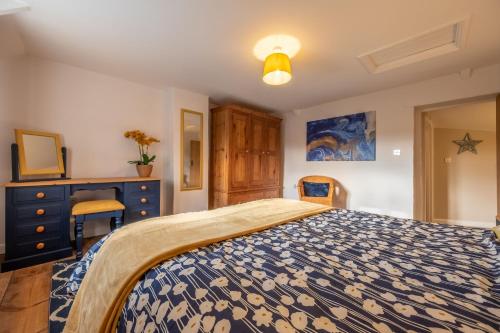 a bedroom with a bed with a blue and white bedspread at Wishing Well Cottage in North Creake