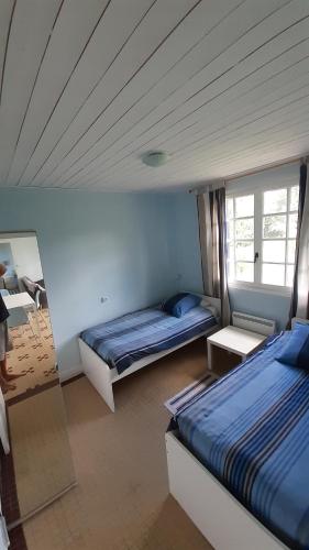 een slaapkamer met 2 bedden en een spiegel bij Tour Rouge Gites in Virazeil