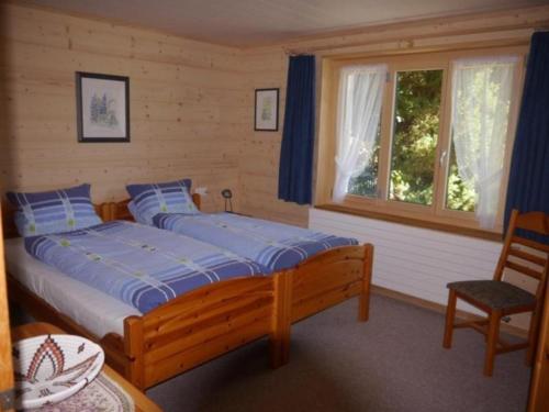 een slaapkamer met een groot bed en een raam bij Birkli 2, 2 Bett Wohnung in Wengen