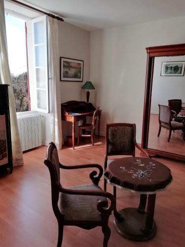 - un salon avec une table, des chaises et un piano dans l'établissement Domaine des Tonneaux, à Jarnac-Champagne