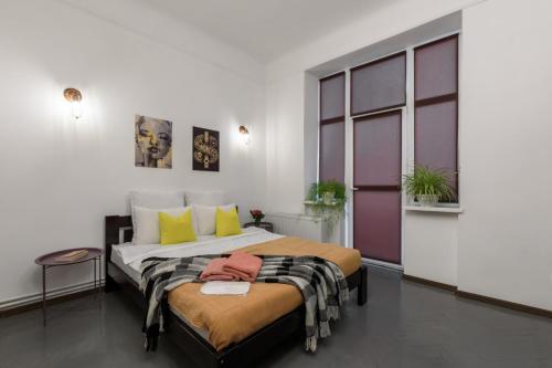 a bedroom with a large bed with yellow and purple accents at Апартаменти в історичному центрі міста Чернівці in Chernivtsi