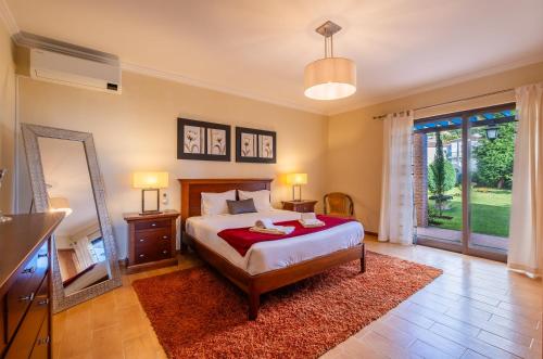 a bedroom with a large bed and a mirror at Quinta D. Maria & Inês in Vila Franca do Campo