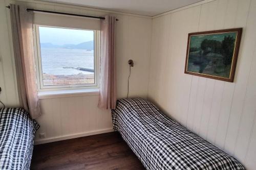 um quarto com duas camas e uma janela em Apartment Solbakken Feriehus em Fevåg