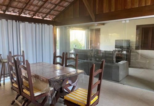 ein Esszimmer mit einem Tisch und Stühlen sowie ein Wohnzimmer in der Unterkunft Paraíso no Sudoeste in São Pedro da Aldeia