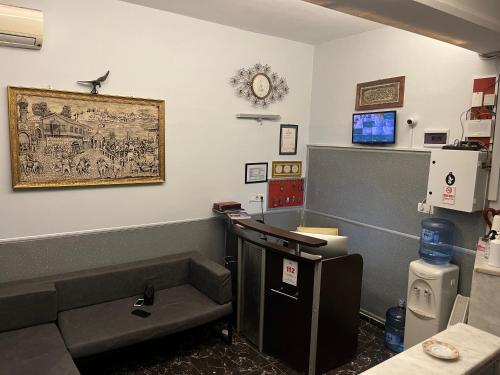 een wachtkamer met een bank en een foto aan de muur bij sultan studio pansiyon in Istanbul