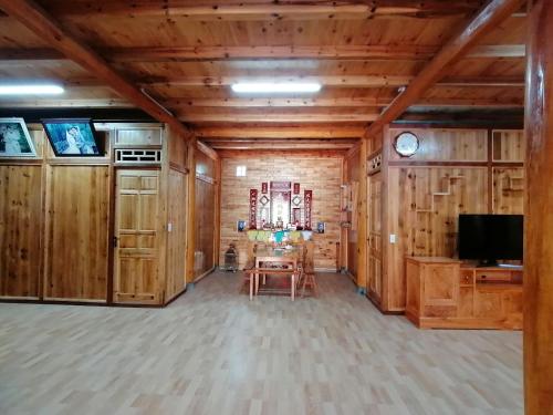 a room with wooden walls and a table and a television at Phố Bảng Homestay in Pho Bang