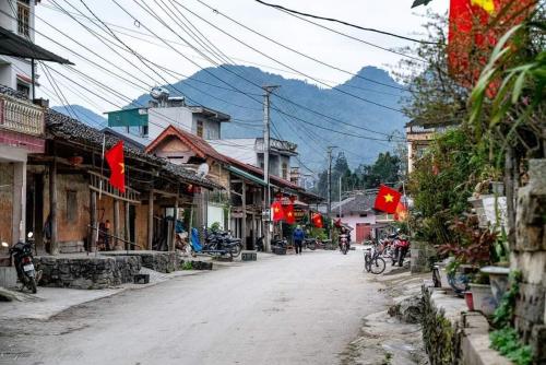 an empty street in a town with mountains in the background at Phố Bảng Homestay in Pho Bang