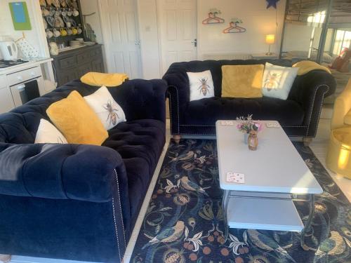 a living room with two couches and a coffee table at Owls Nest Log Cabin in Morpeth