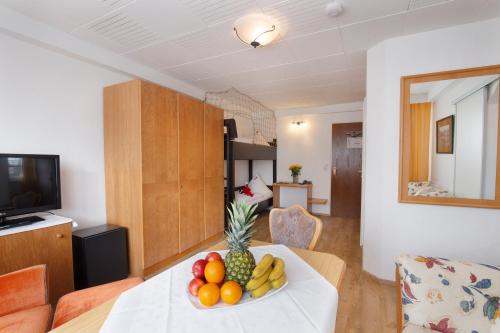 a room with a table with a bowl of fruit on it at Bodensee Hotel Storchen in Uhldingen-Mühlhofen