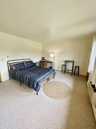 een slaapkamer met een bed en een tafel en stoelen bij Carriage Hill Apartment #11 in Whitewater