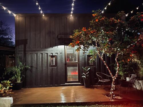 una casa con terrazza in legno di notte con luci di Likod Bahay Cabin 