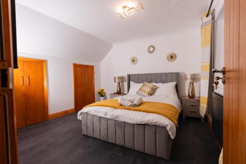 a bedroom with a large bed with a yellow blanket at Sweet Dreams in Peterborough